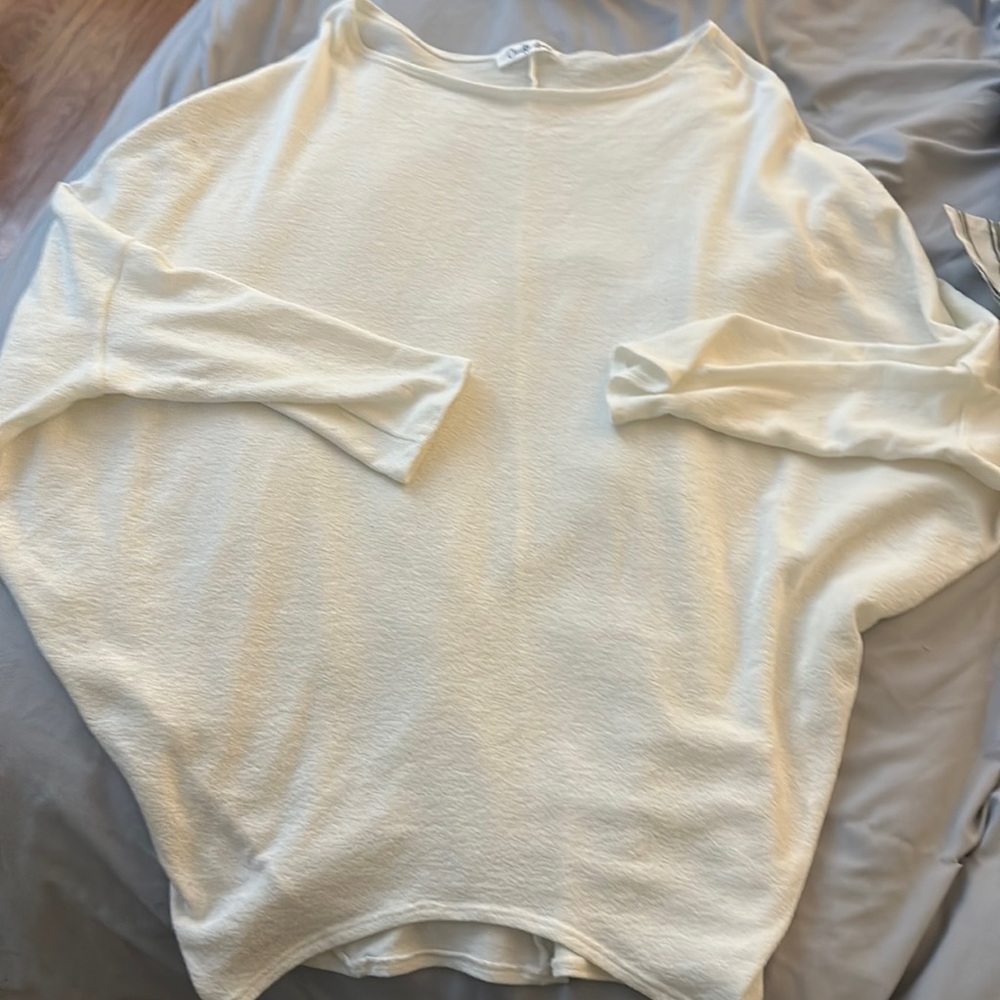Off-white, oversized, mid-length sleeve top.
